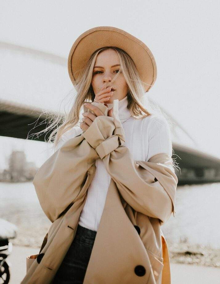 woman in brown sun hat and white coat